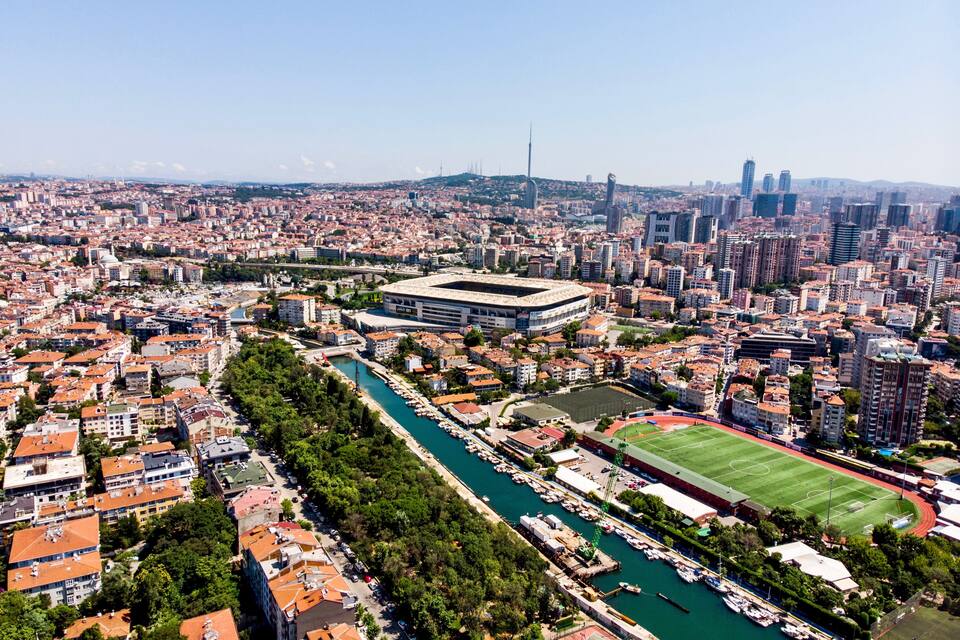 Une vue urbaine comprenant une rivière, un stade et des immeubles de grande hauteur.