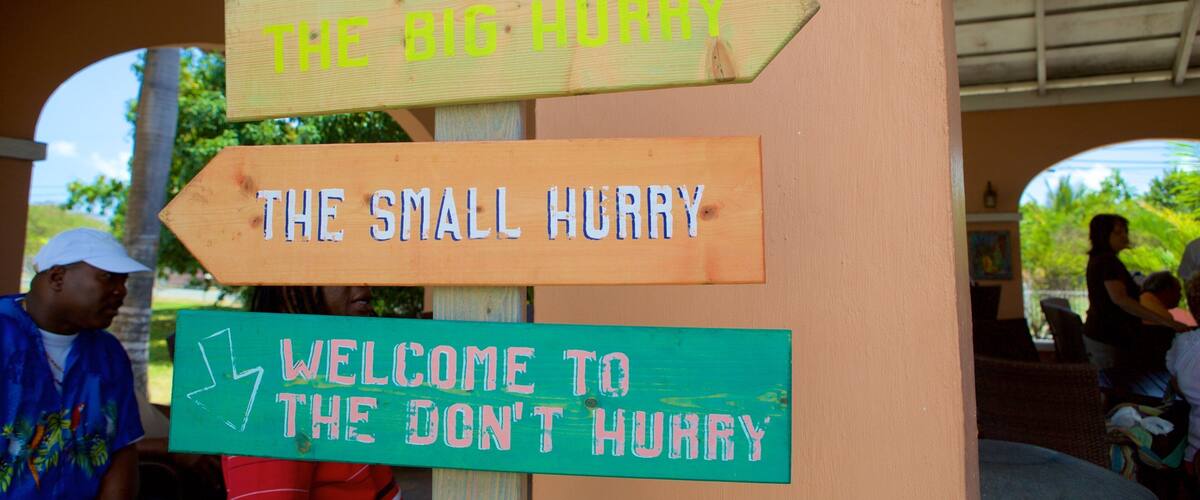 A wooden signpost with directional signs and a 'Welcome to the Don't Hurry' sign.