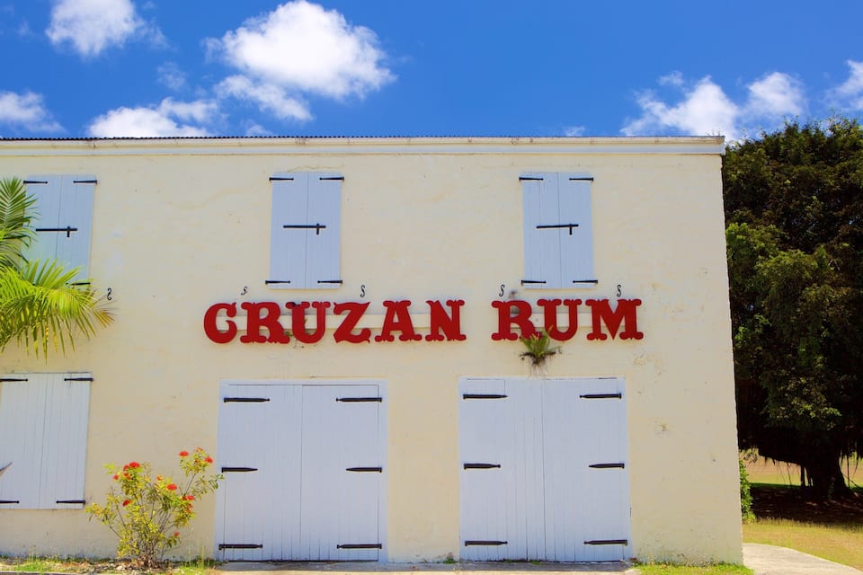 A building with a sign reading "CRUZAN RUM" and white shutters.
