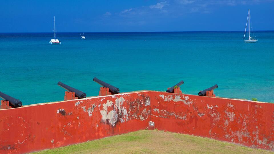 A red fort with cannons overlooking turquoise waters.