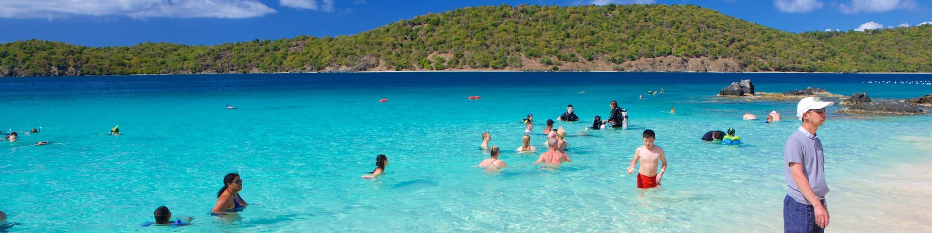 Coki Beach featuring a beach as well as a small group of people