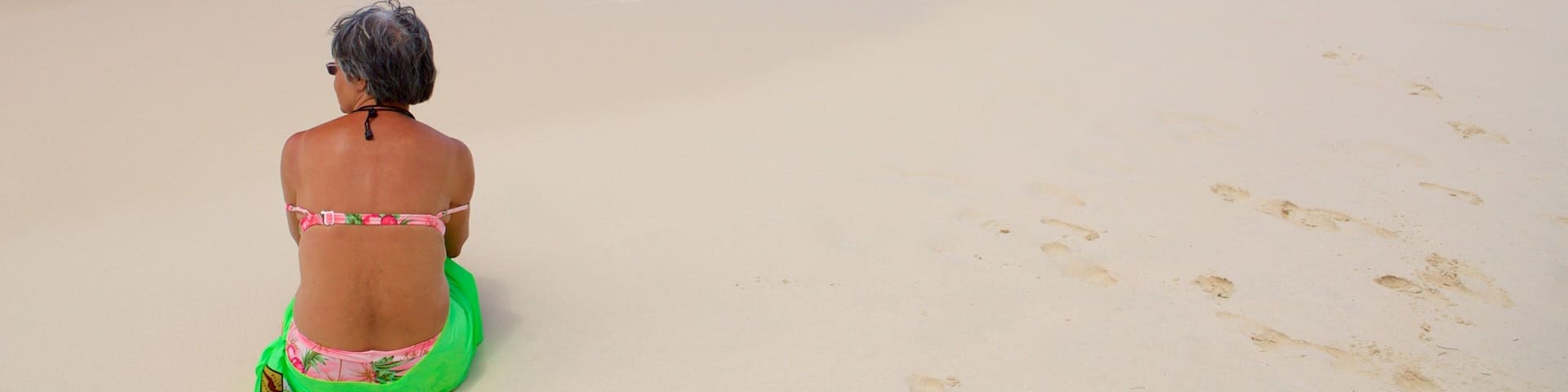 Trunk Bay featuring a sandy beach as well as an individual femail