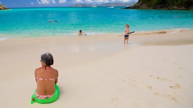 Trunk Bay featuring a sandy beach as well as an individual femail