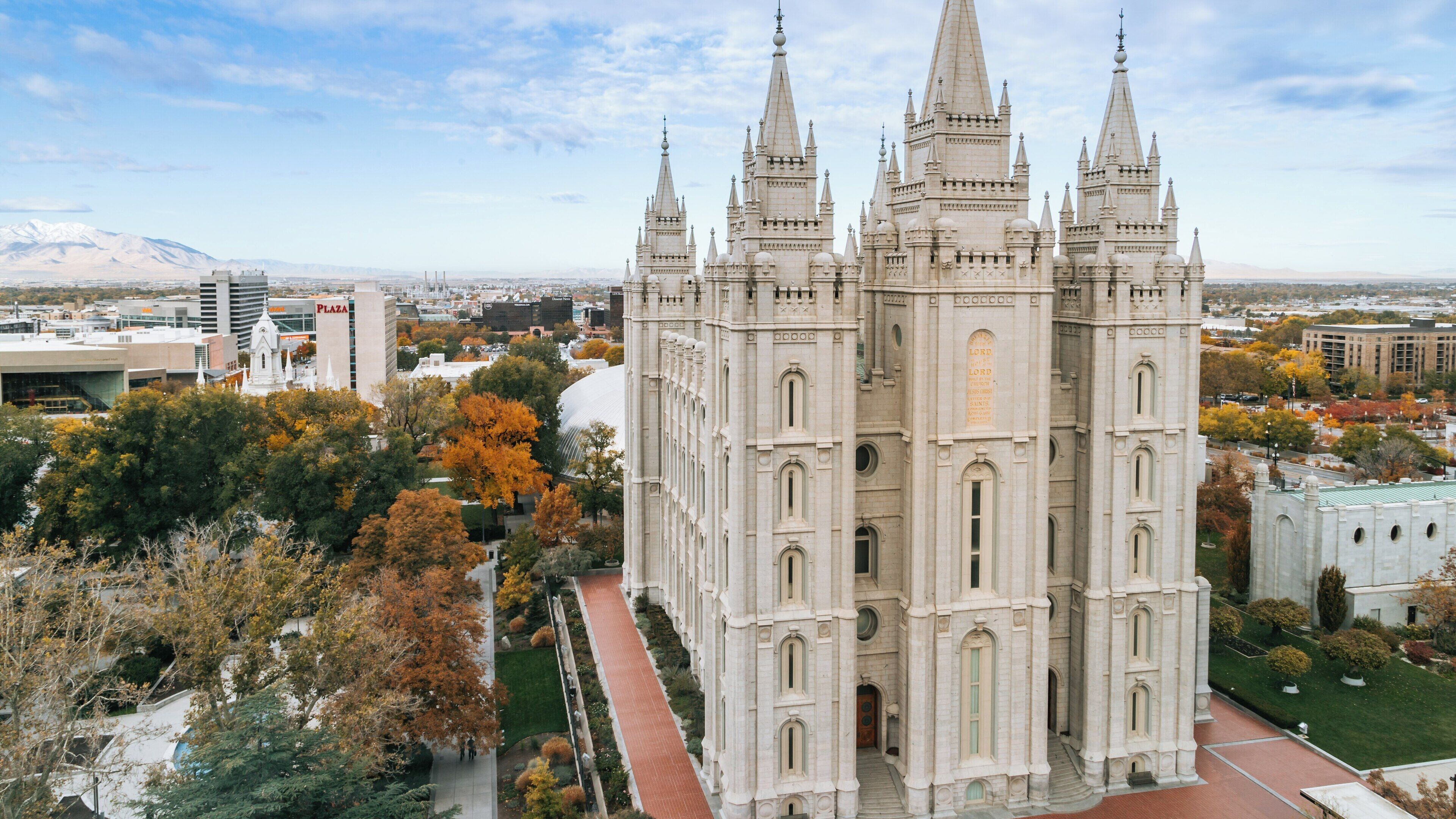Majestic Salt Lake Temple stands tall amidst vibrant autumn foliage in downtown Salt Lake City, Utah, showcasing remarkable architecture and history