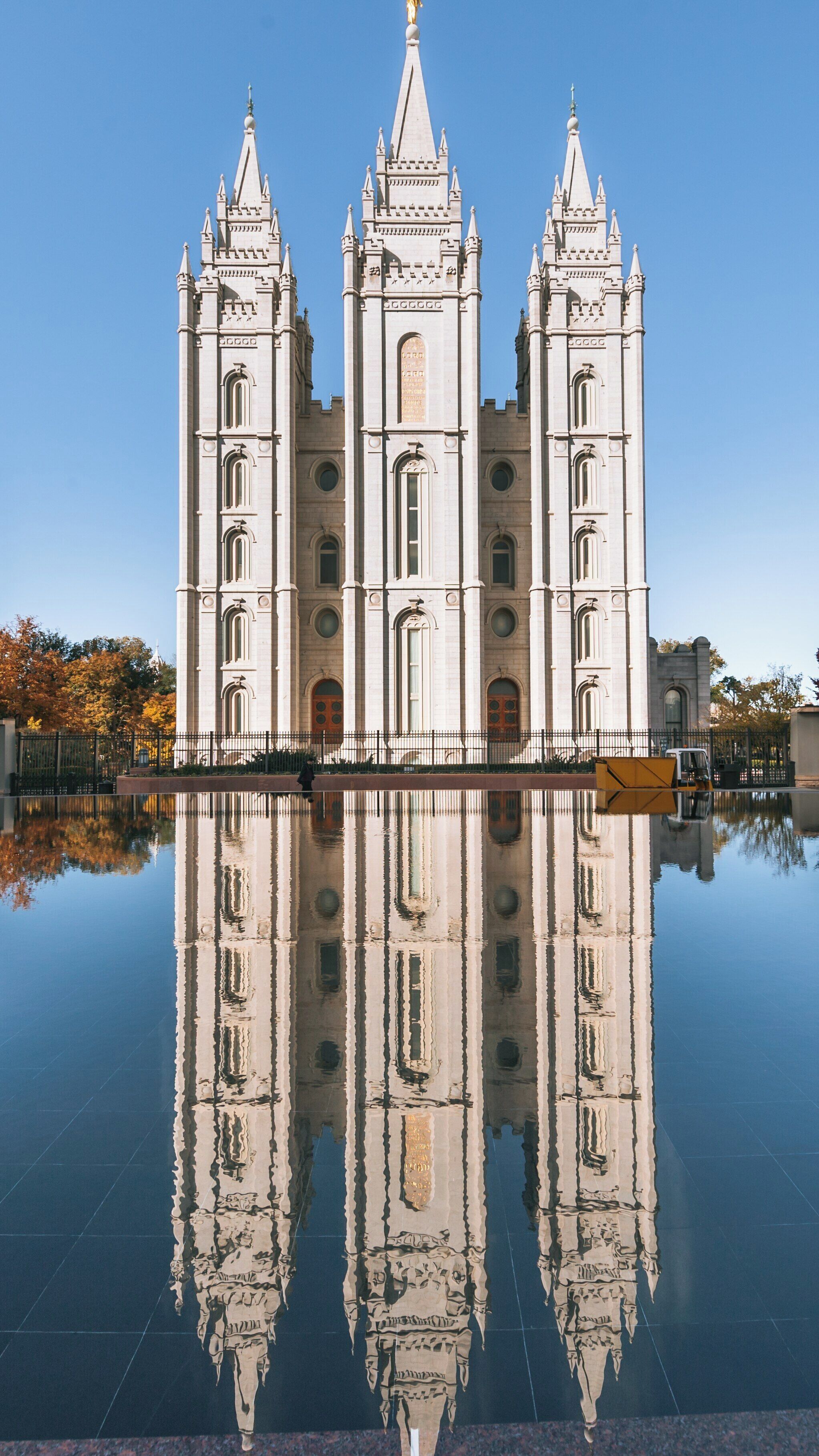 Majestic Salt Lake Temple stands in Downtown Salt Lake City reflecting beautifully in the serene water on a clear day