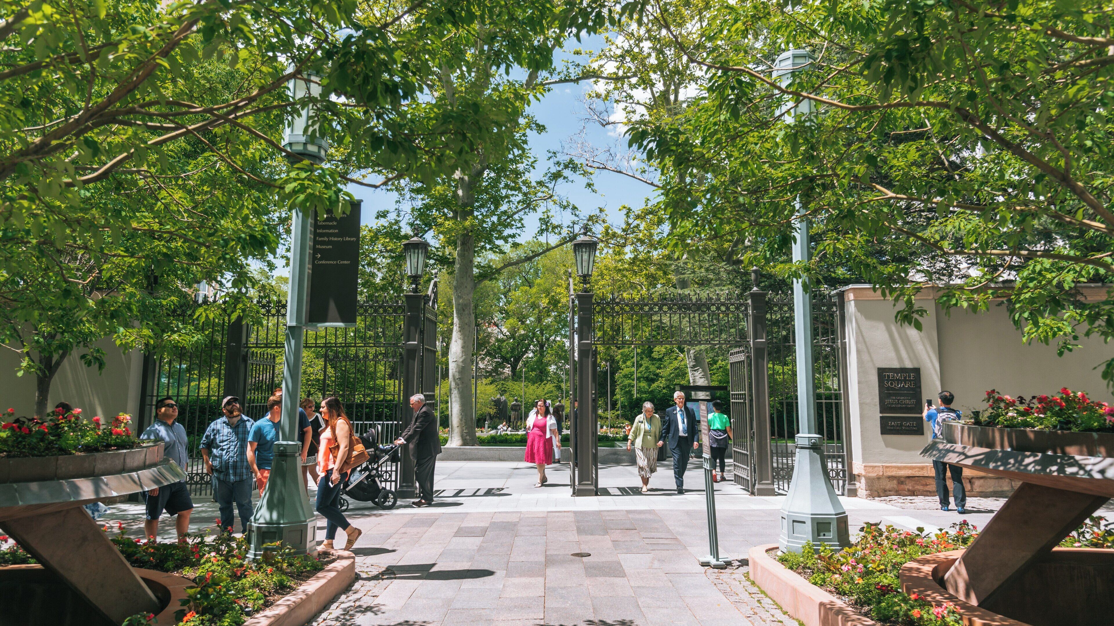 Visitors explore the lush pathways and gardens of Temple Square in downtown Salt Lake City, Utah on a sunny afternoon