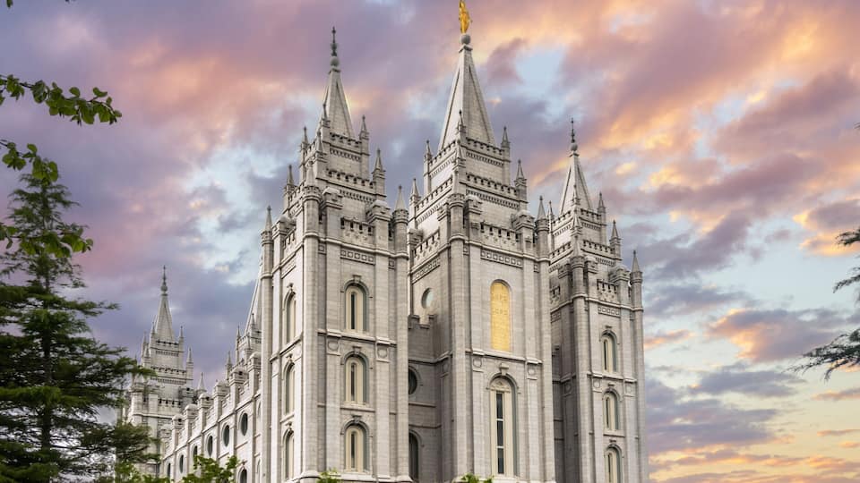 A grand, Gothic-style cathedral with multiple spires and a golden statue on top.