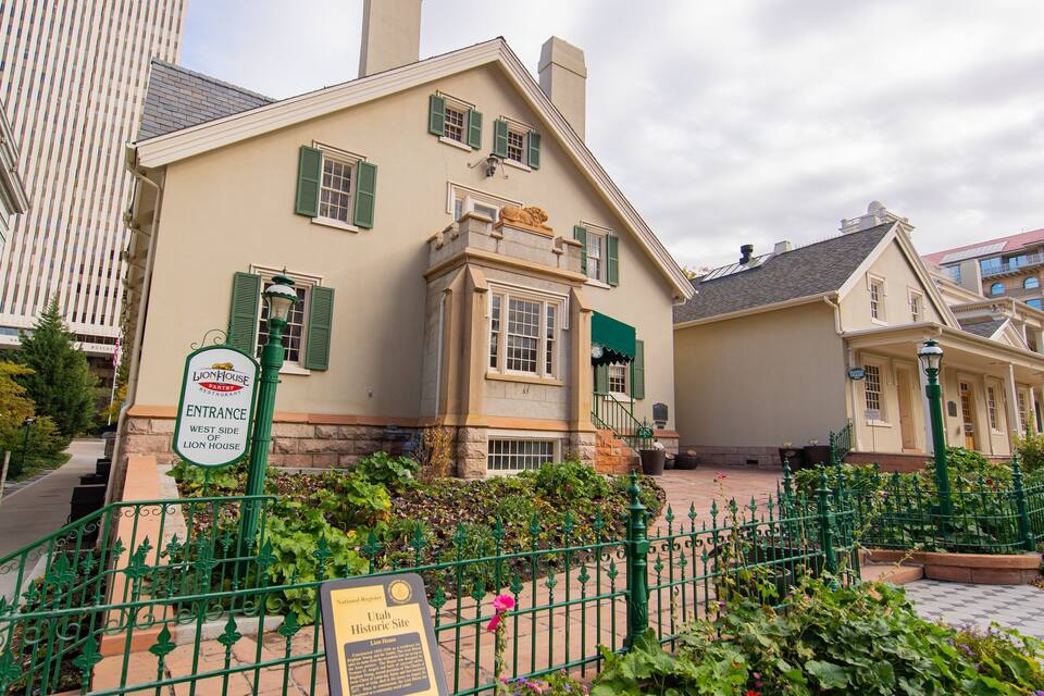 A historic building with green shutters and a sign indicating it's the entrance to the Lion House restaurant.
