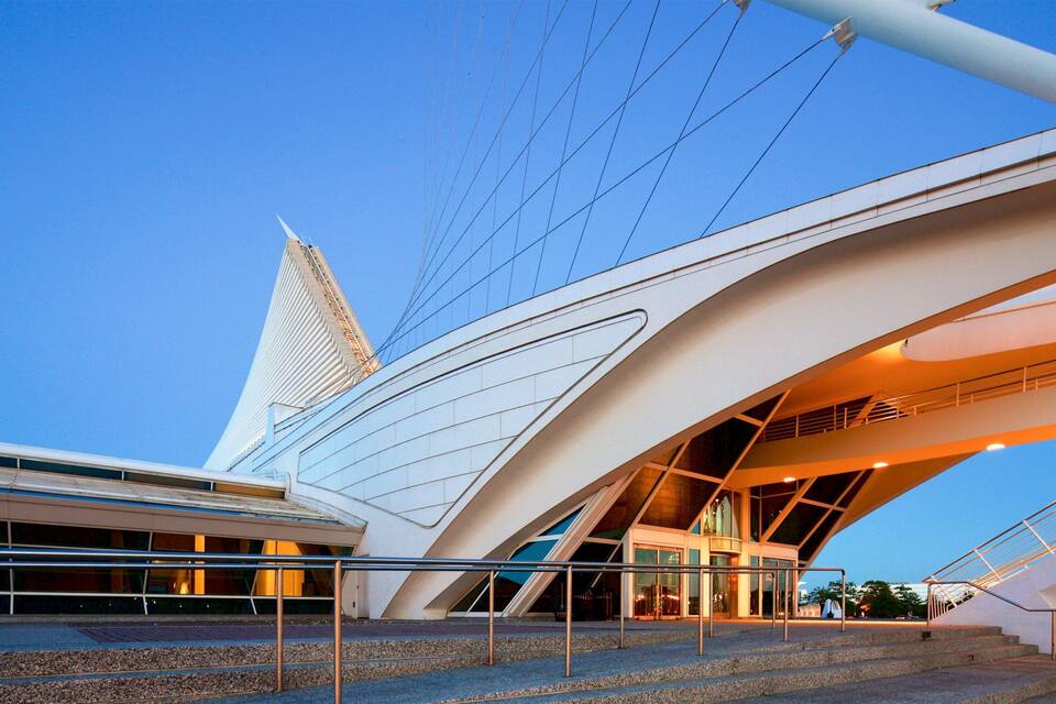 A modern architectural building with a unique design, featuring a prominent tower and curved structures.