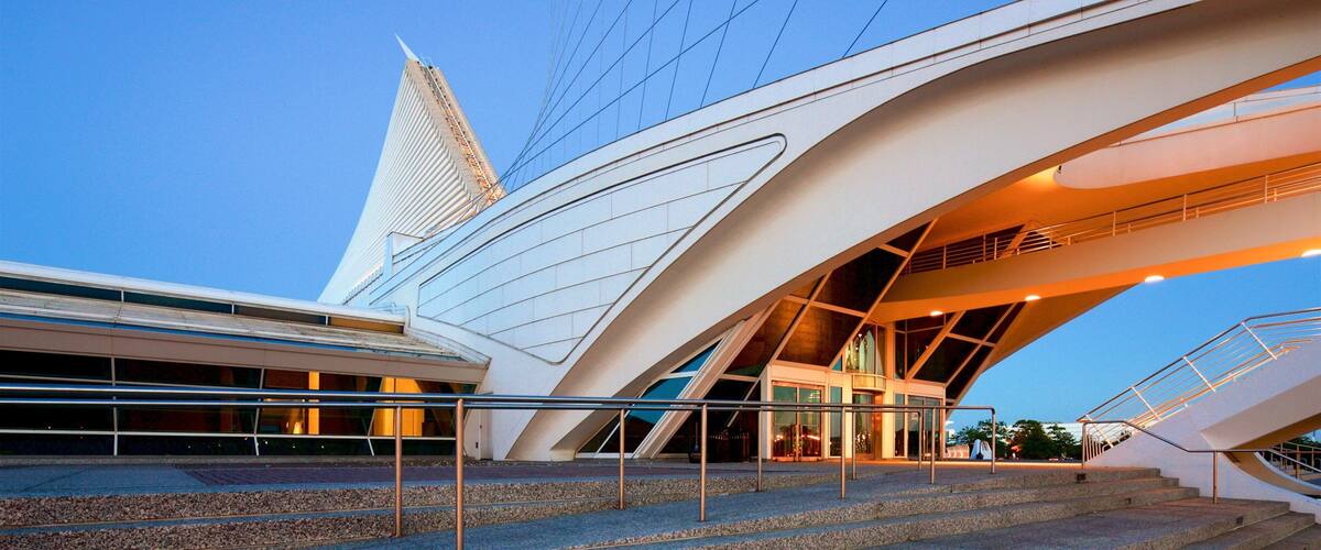 A modern architectural building with a unique design, featuring a prominent tower and curved structures.