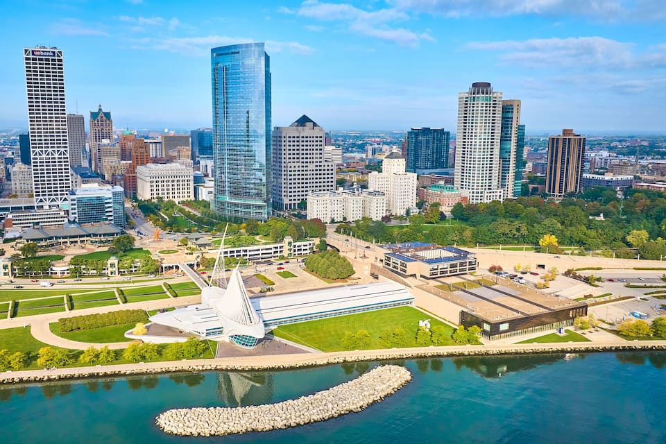 A cityscape with modern skyscrapers, a central park, and a waterfront.