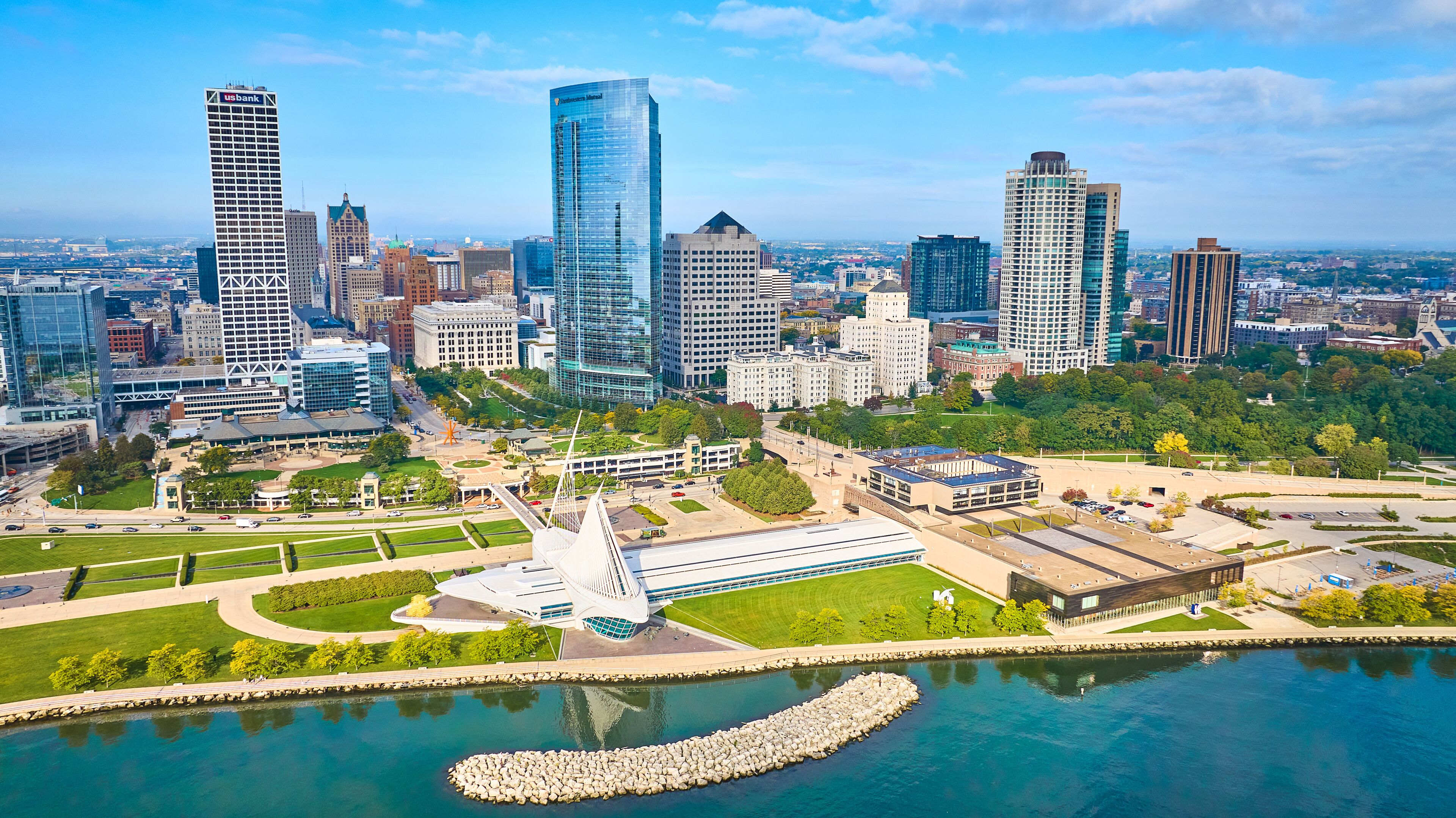 A cityscape with modern skyscrapers, a central park, and a waterfront.