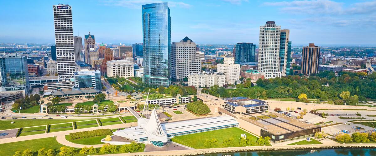 A cityscape with modern skyscrapers, a central park, and a waterfront.