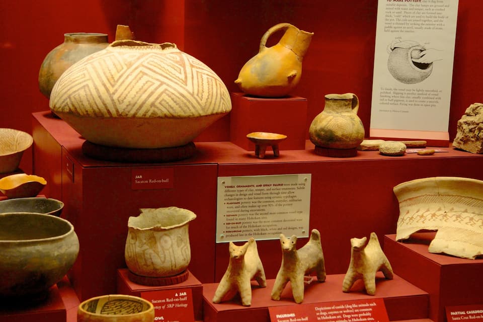 Une collection de poteries et de figurines anciennes est exposée.
