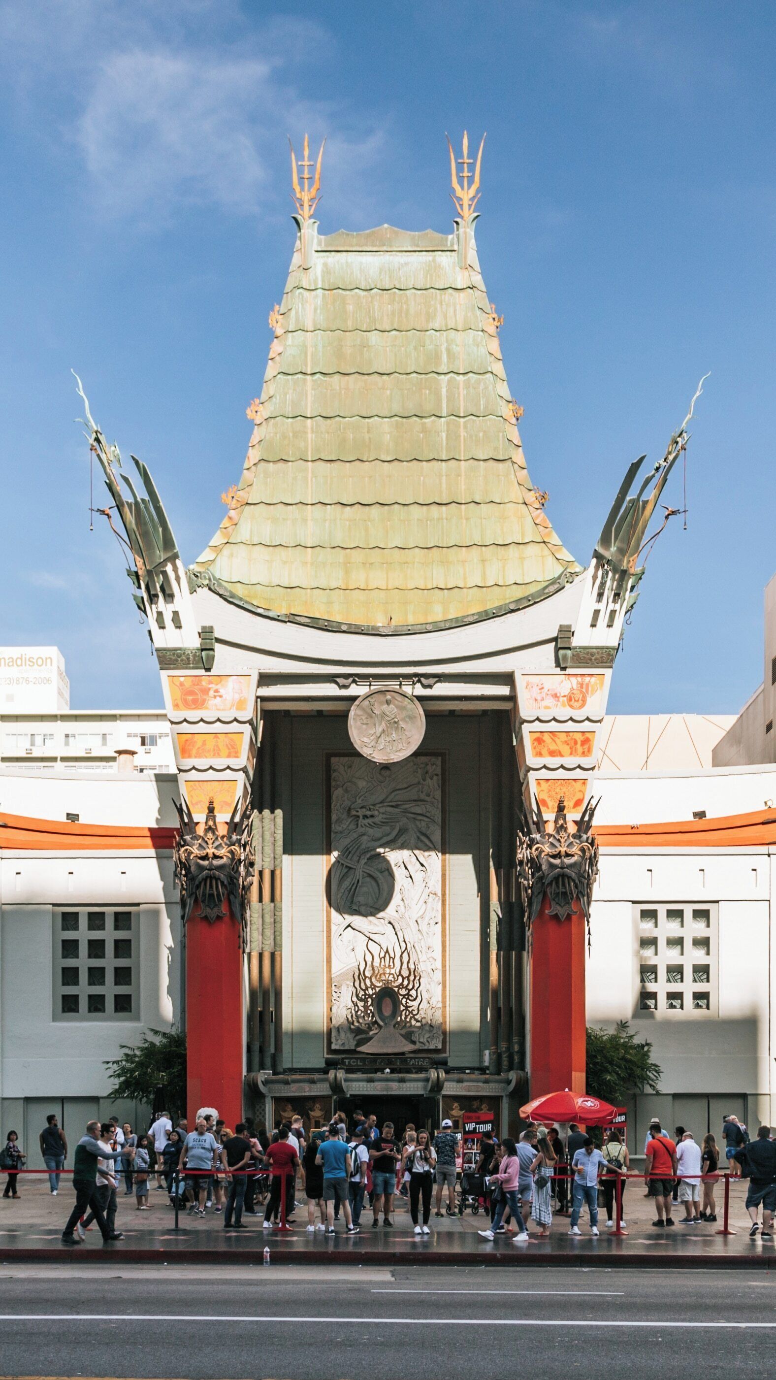 Visiting TCL Chinese Theatre in Hollywood, a landmark of cinematic history in Los Angeles, California, bustling with tourists and movie fans under clear blue skies