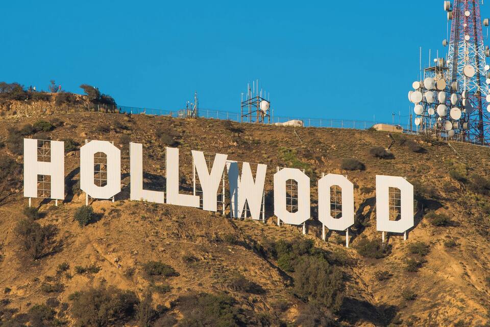 The Hollywood sign on a hill with a clear blue sky.