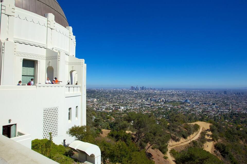 Un edificio blanco con cúpula y ventanas arqueadas que dan vistas a un paisaje urbano.