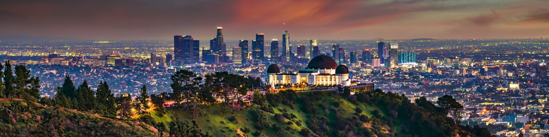 A cityscape with a prominent dome-shaped building, a dense urban area, and a dramatic sky with clouds.