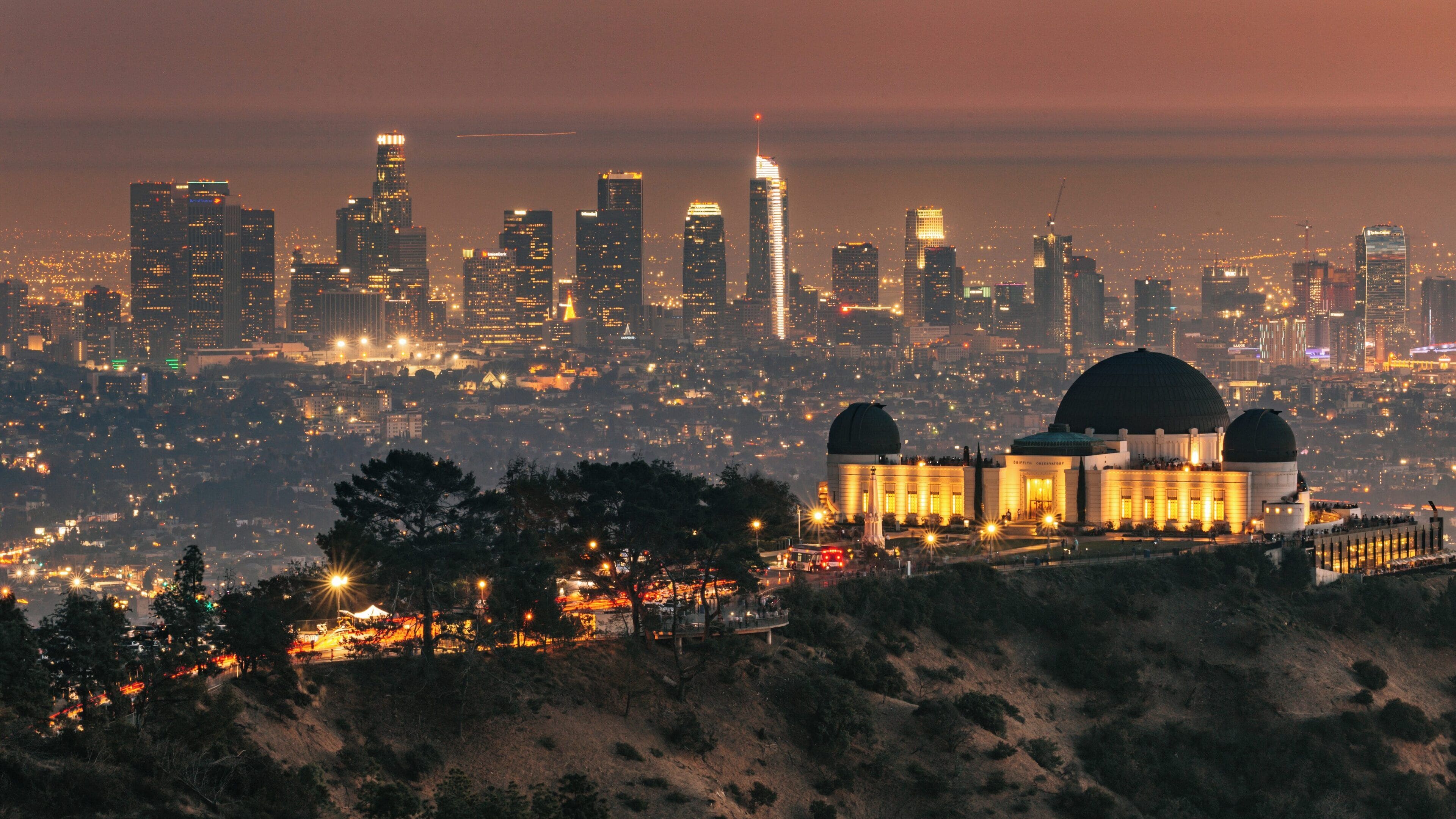 Griffith Observatory offers a stunning view of Los Angeles skyline at dusk with city lights twinkling below and a peaceful atmosphere