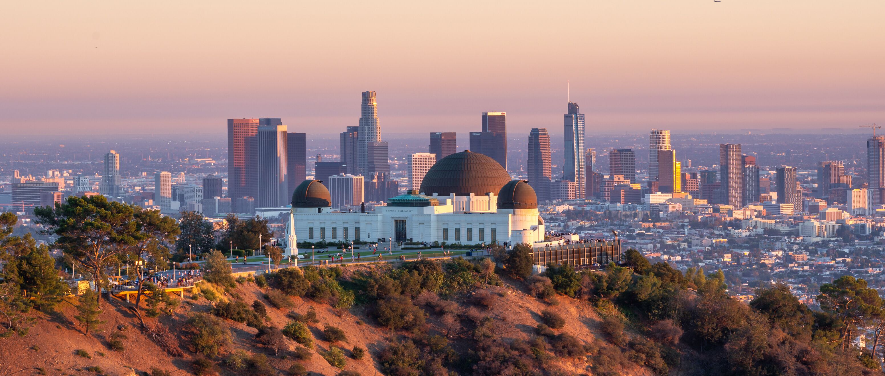 A cityscape with a prominent domed building surrounded by a hilly landscape and a dense urban skyline.