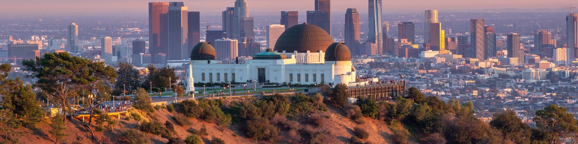 A cityscape with a prominent domed building surrounded by a hilly landscape and a dense urban skyline.