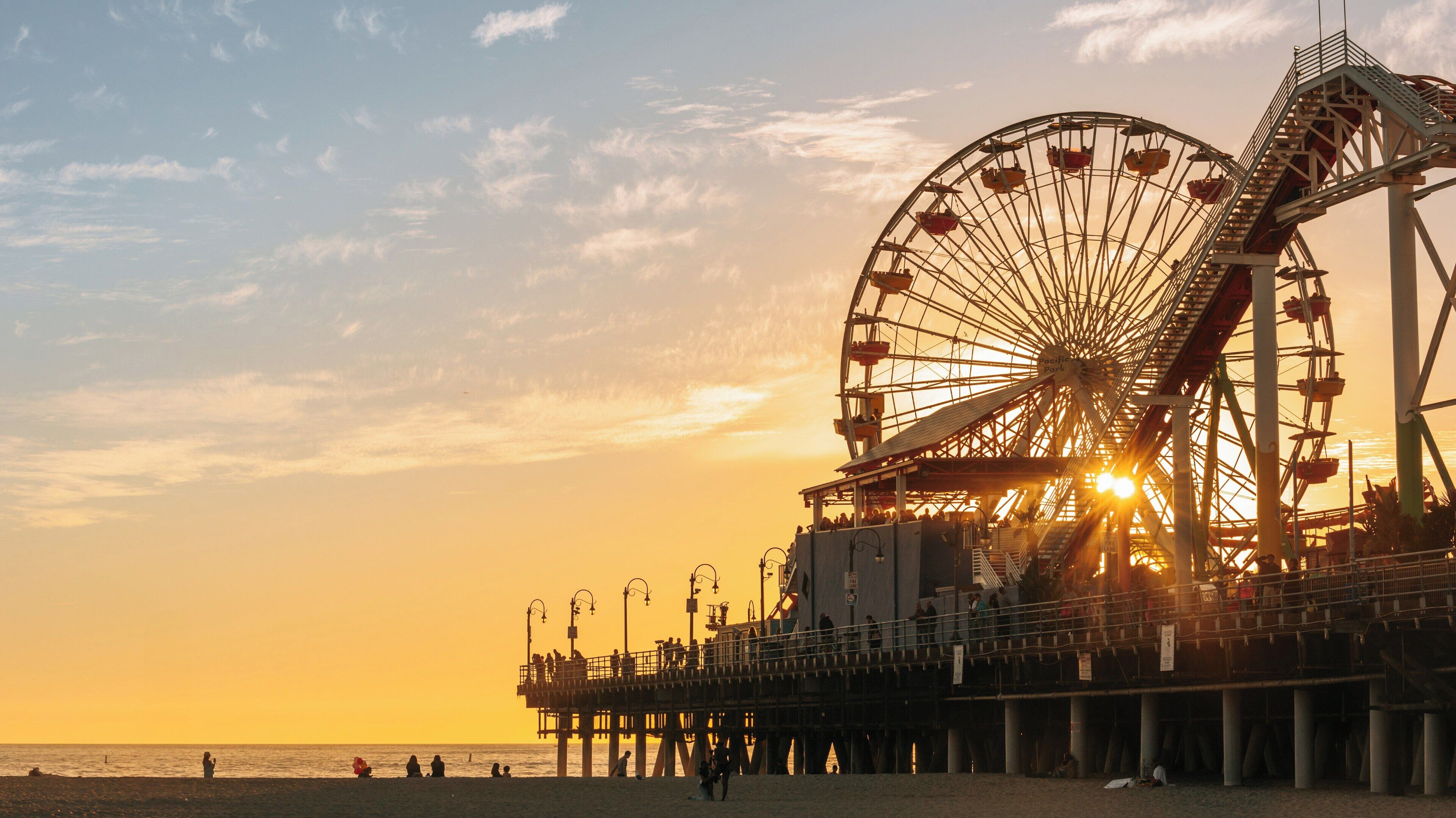 Santa Monica Pier offers stunning sunset views with visitors enjoying the vibrant atmosphere near the beach in California