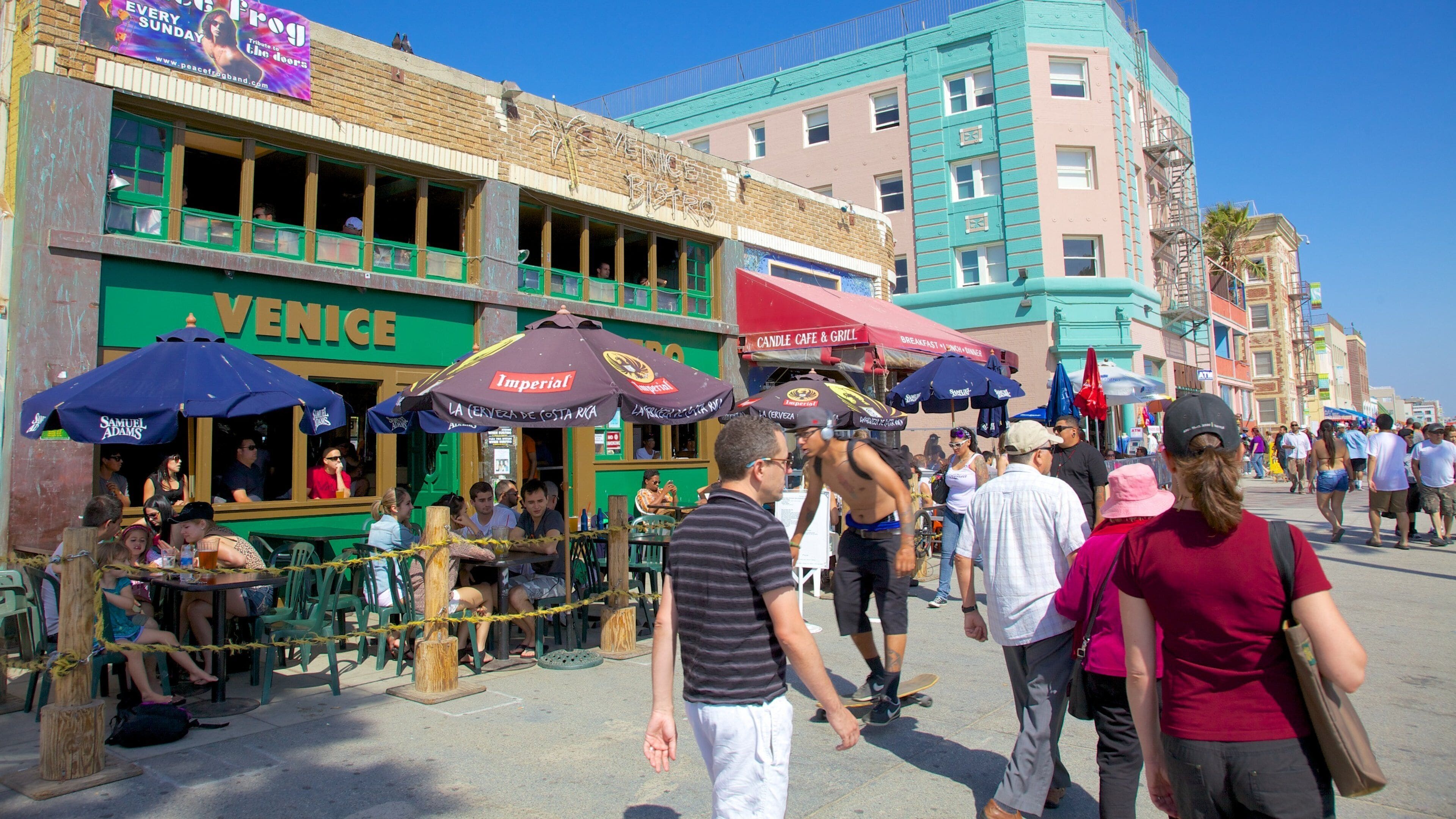 Visitors enjoy a vibrant day at Venice Beach with shops, cafes, and lively street activities in California