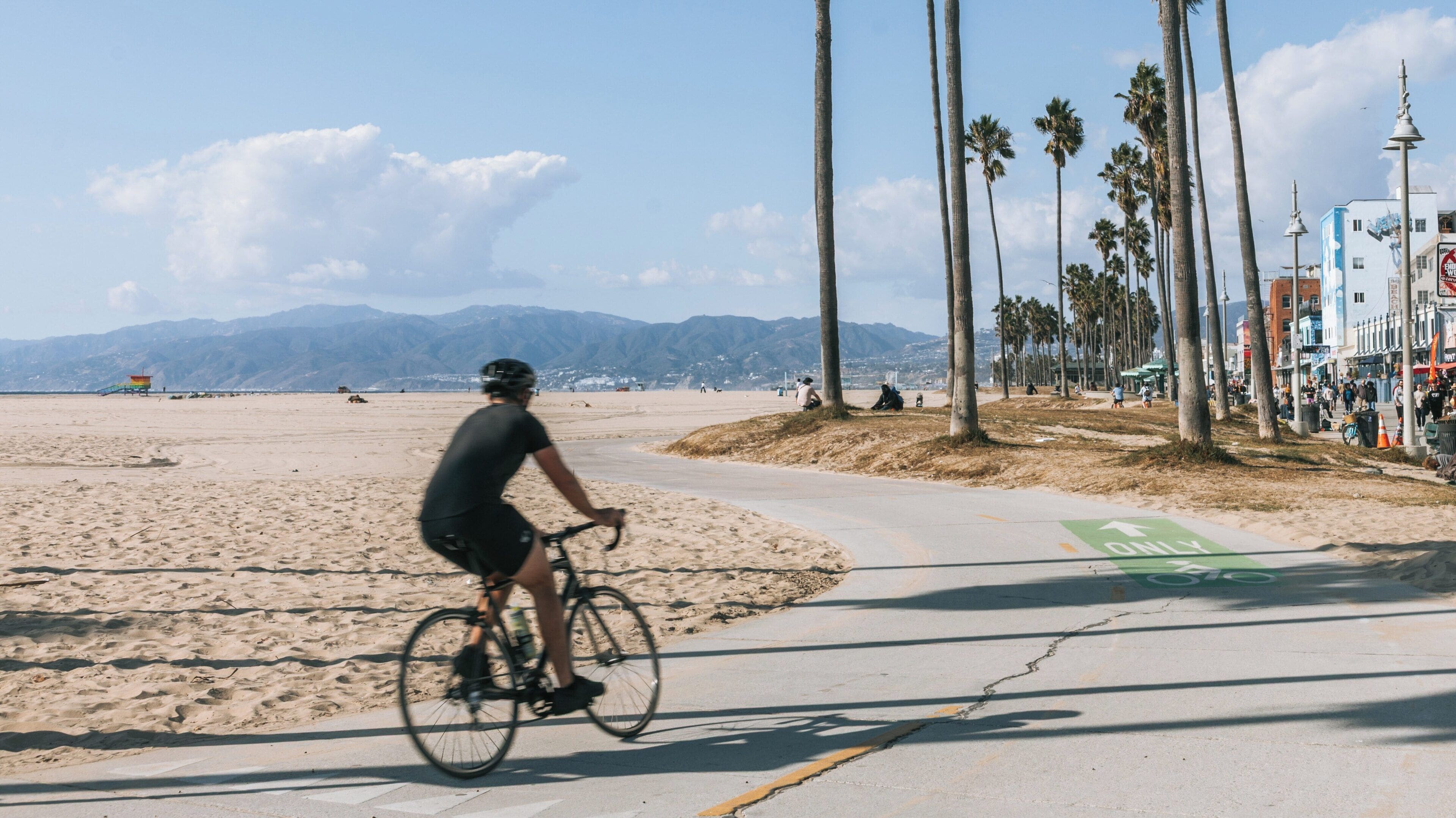 Cyclist rides along the path at Venice Beach near Marina Peninsula in California on a sunny day