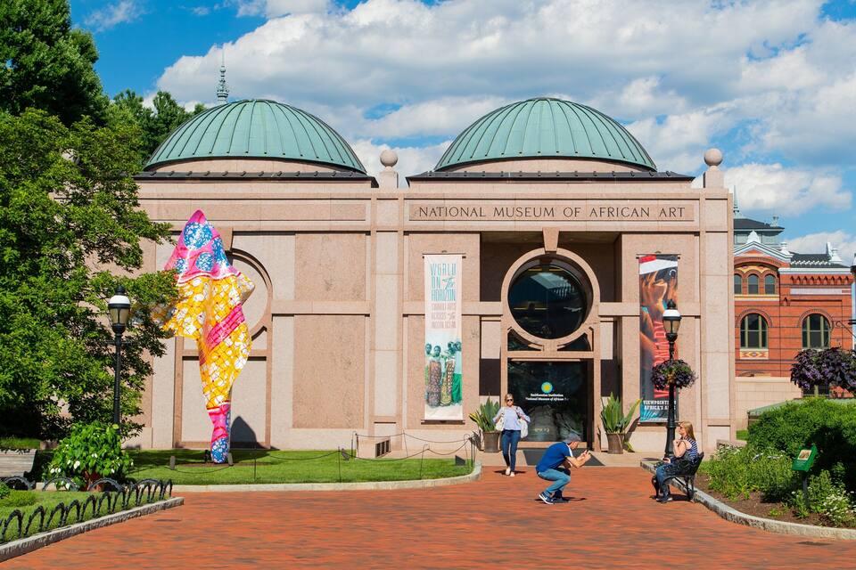 The National Museum of African Art with two domed roofs and a large sculpture in front.