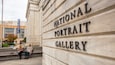 El edificio de la National Portrait Gallery con una mujer sentada en los escalones.