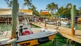 Un puerto deportivo con barcos amarrados, un muelle de madera y un letrero que dice 'Robbie's'.