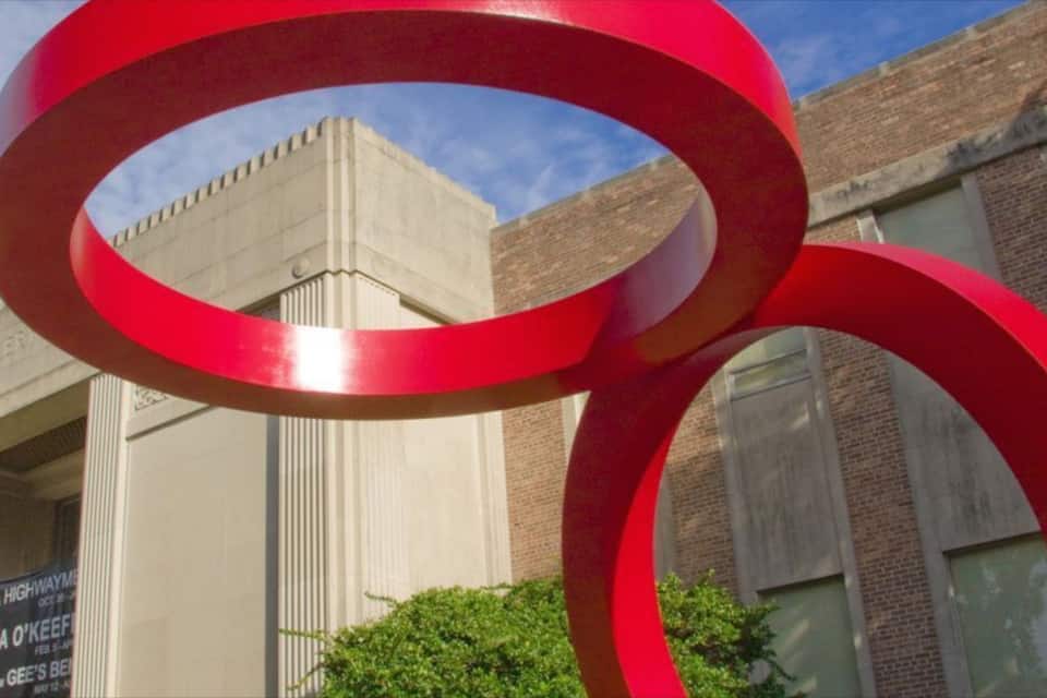 A red sculpture in front of a building with a sign that reads "Florida Highway 92".