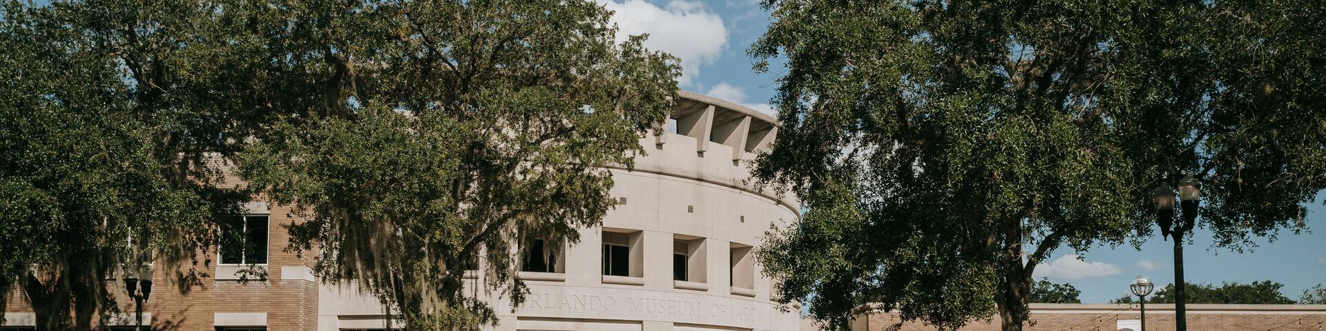 The Orlando Museum of Art with a brick facade, large windows, and surrounding trees.