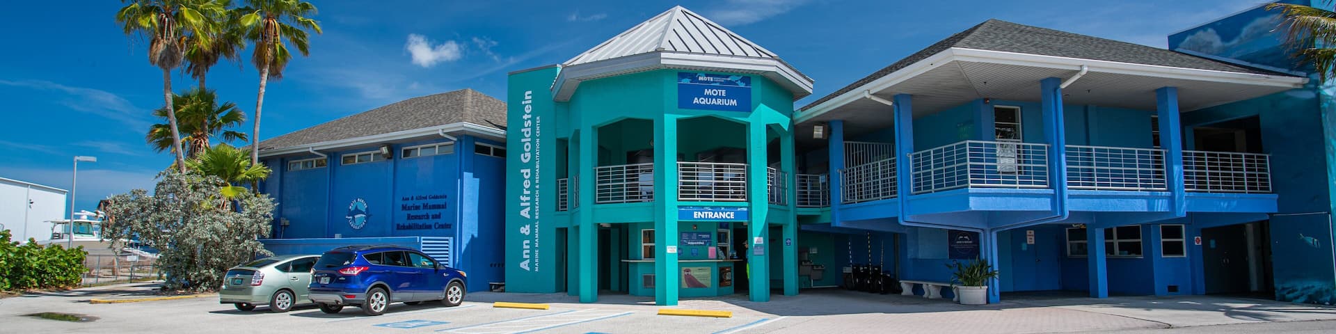 A blue building with a sign that reads "MOTE AQUARIUM" and "Marine Mammal Research and Rehabilitation Center".