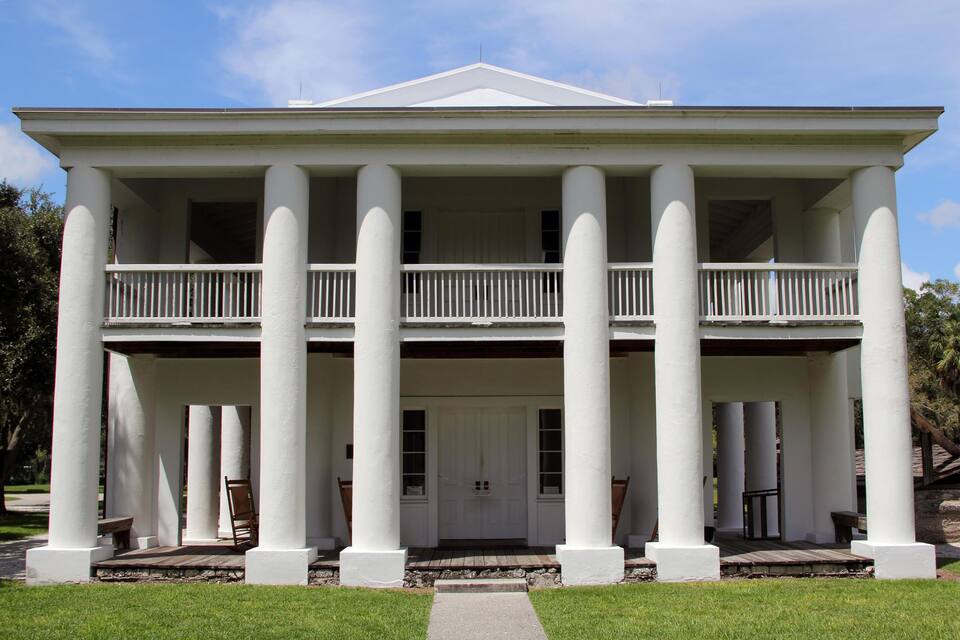 A large white building with columns and a balcony.