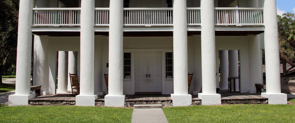 A large white building with columns and a balcony.
