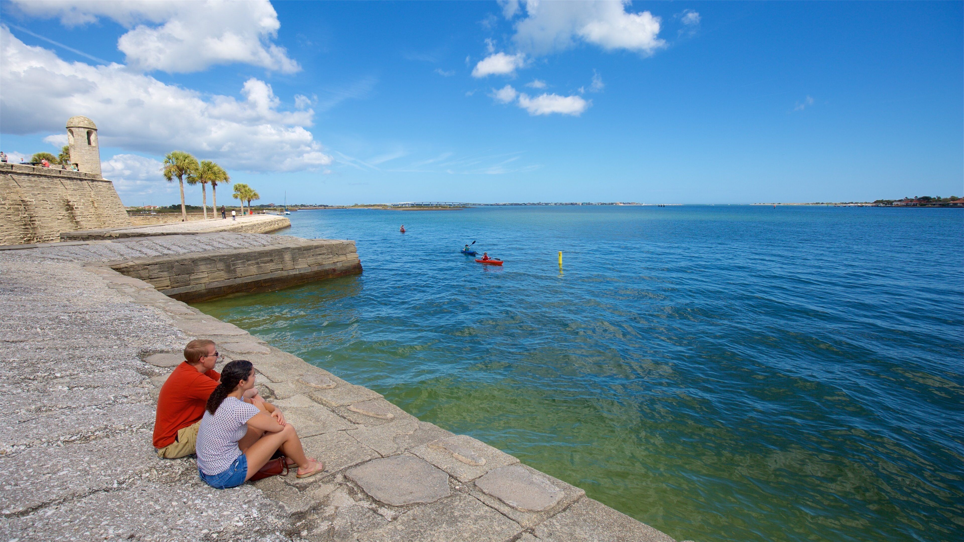 Castillo de San Marcos showing a lake or waterhole as well as a couple