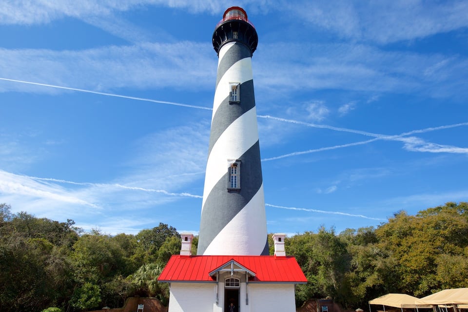 A lighthouse with a red roof and a spiral design.