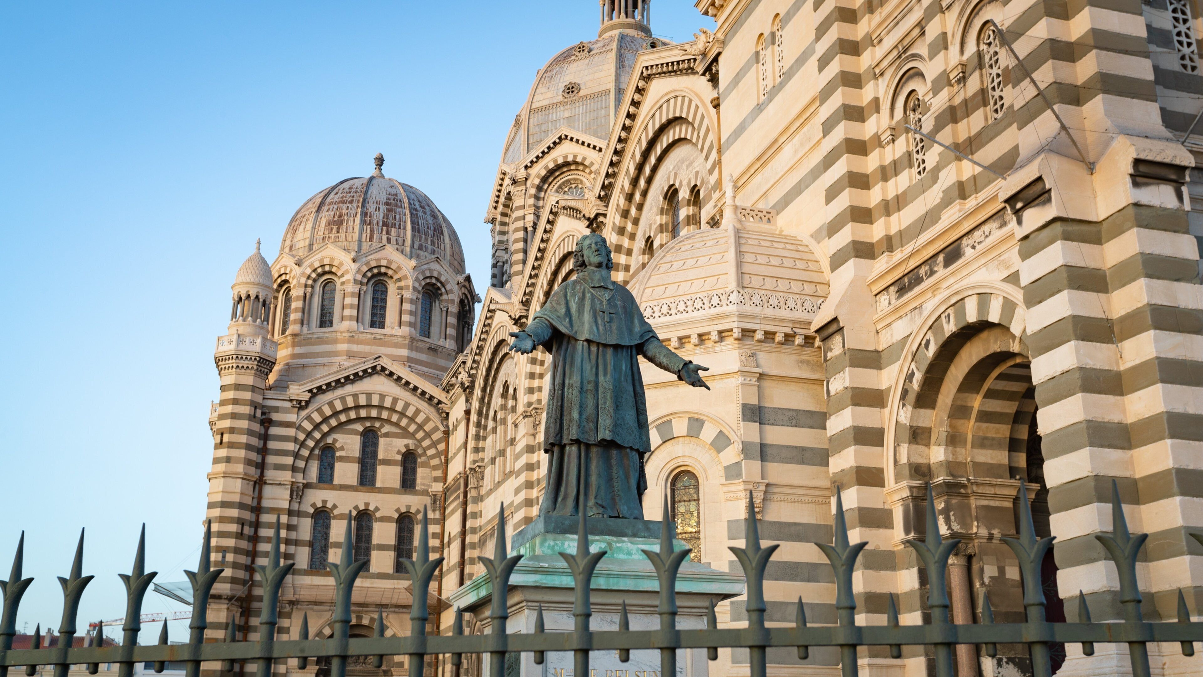 A large ornate building with a statue in front.