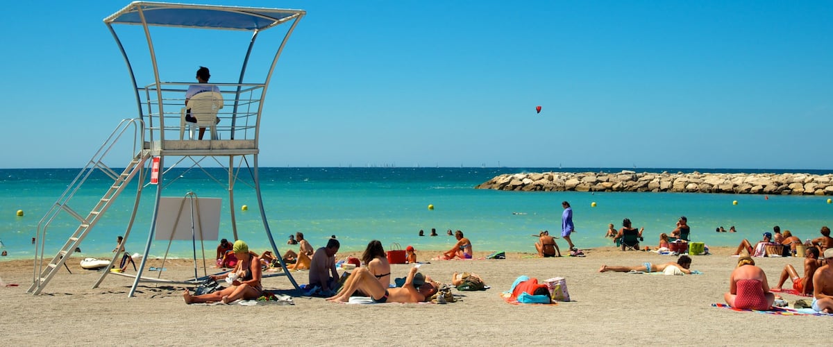 Prado Beach showing general coastal views and a sandy beach as well as a large group of people