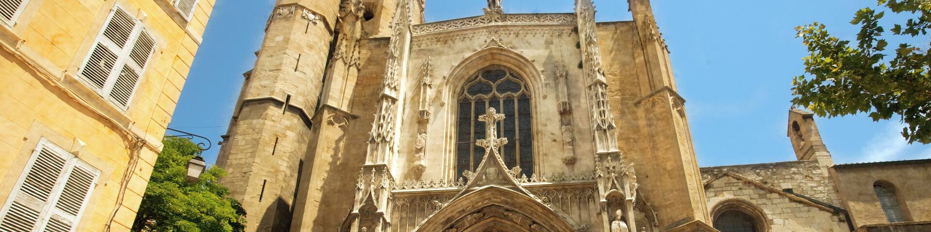 A Gothic cathedral with a tall bell tower, large arched windows, and statues.