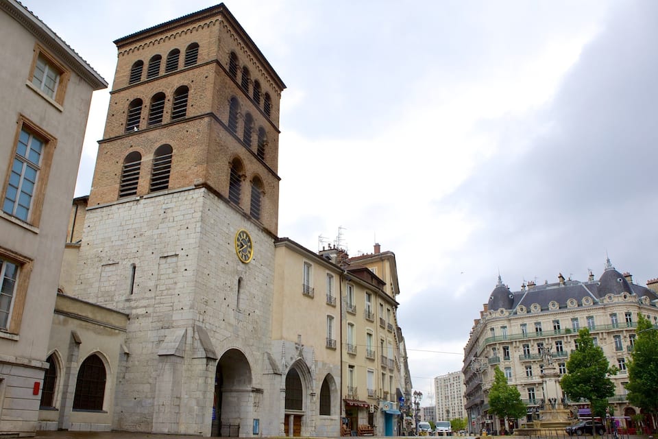 A historic square with a prominent clock tower, a fountain, and classical architecture.