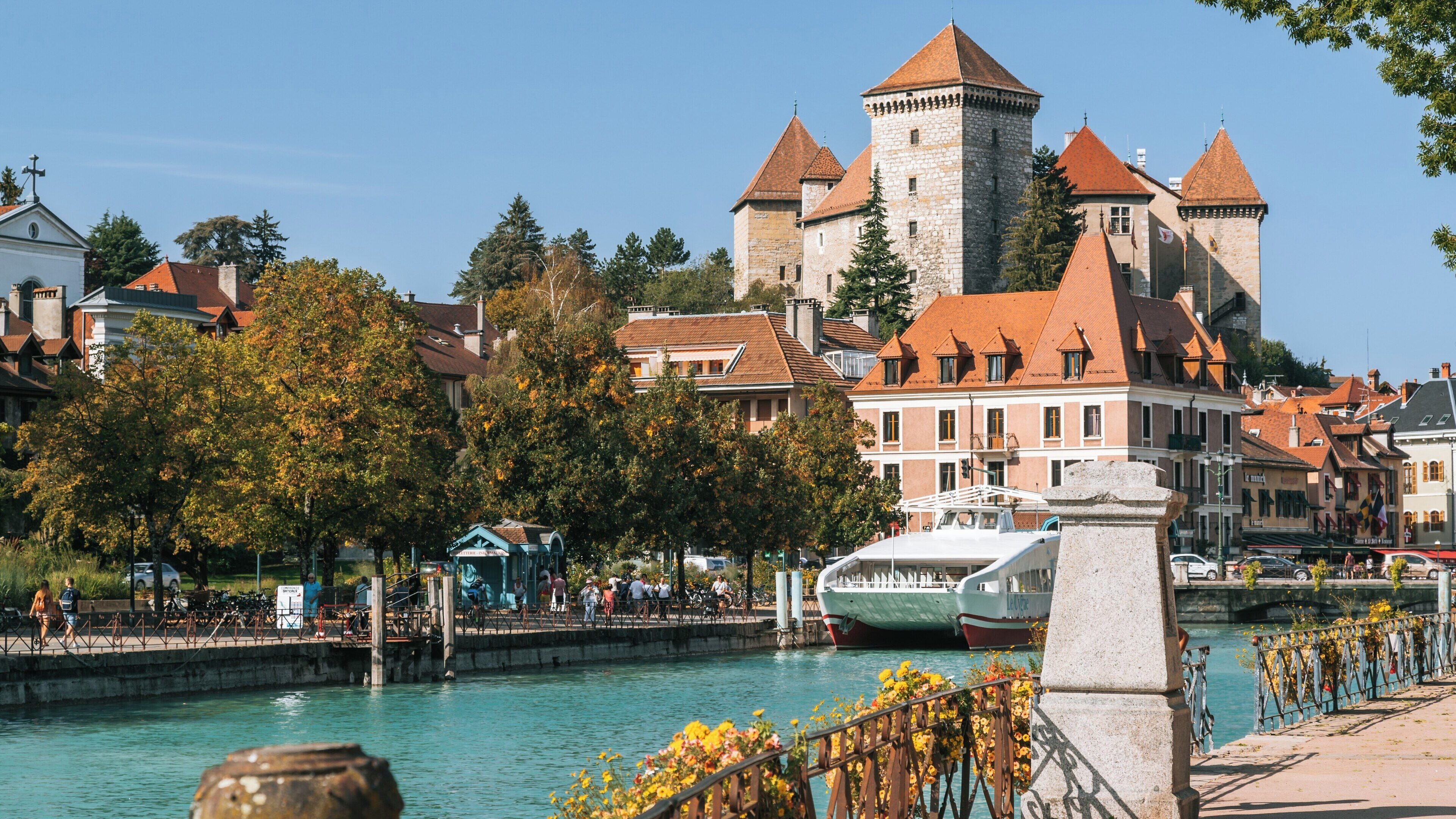 Historic Annecy Castle stands majestically above the picturesque canals of Annecy Old Town in Auvergne-Rhone-Alpes, France on a sunny day