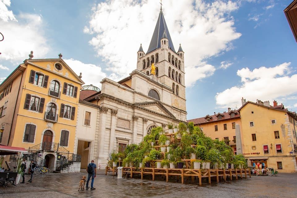 A historic square with a church, a fountain, and surrounding buildings.
