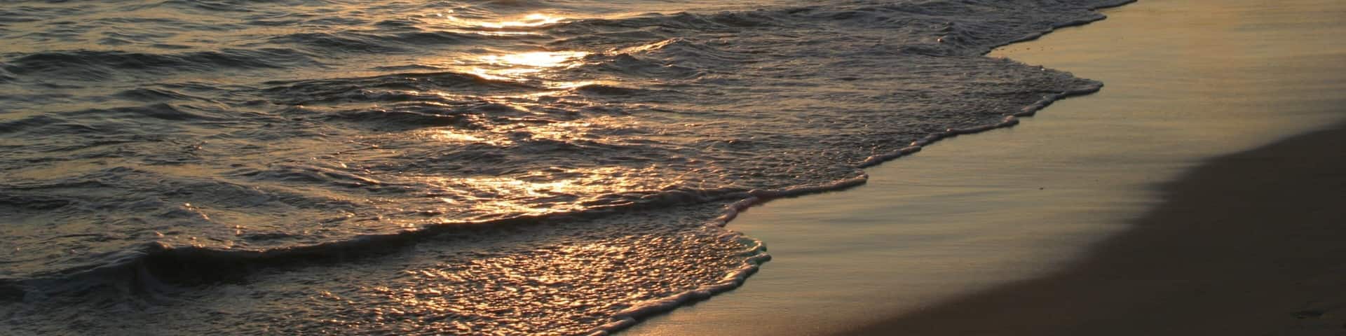 Waimanalo Beach featuring a sandy beach, a sunset and landscape views