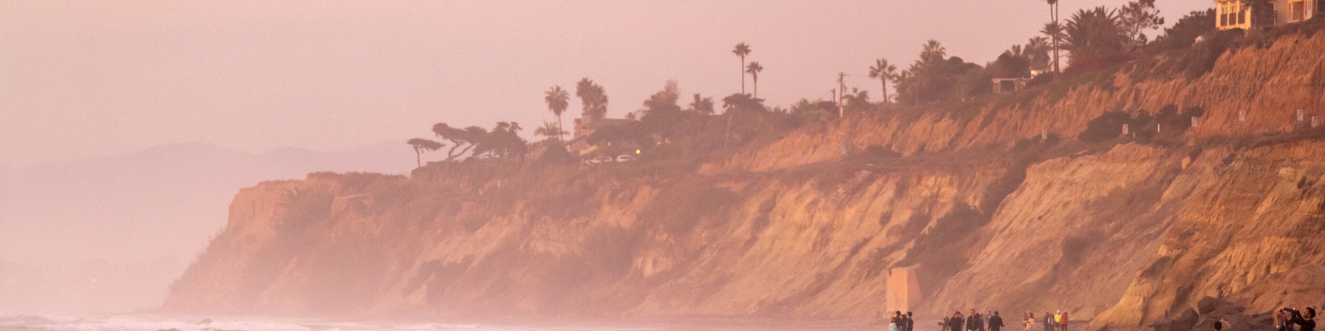 Torrey Pines State Beach showing a sunset, rugged coastline and general coastal views