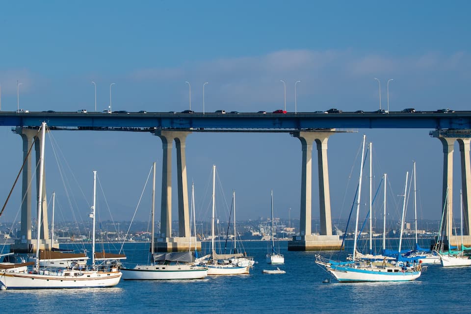 A bridge over water with several boats anchored below.