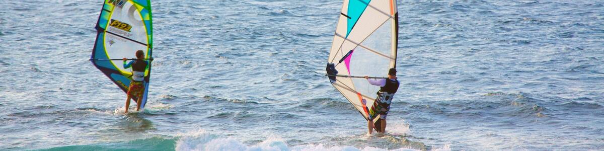 Deux personnes pratiquent la planche à voile dans l’océan.