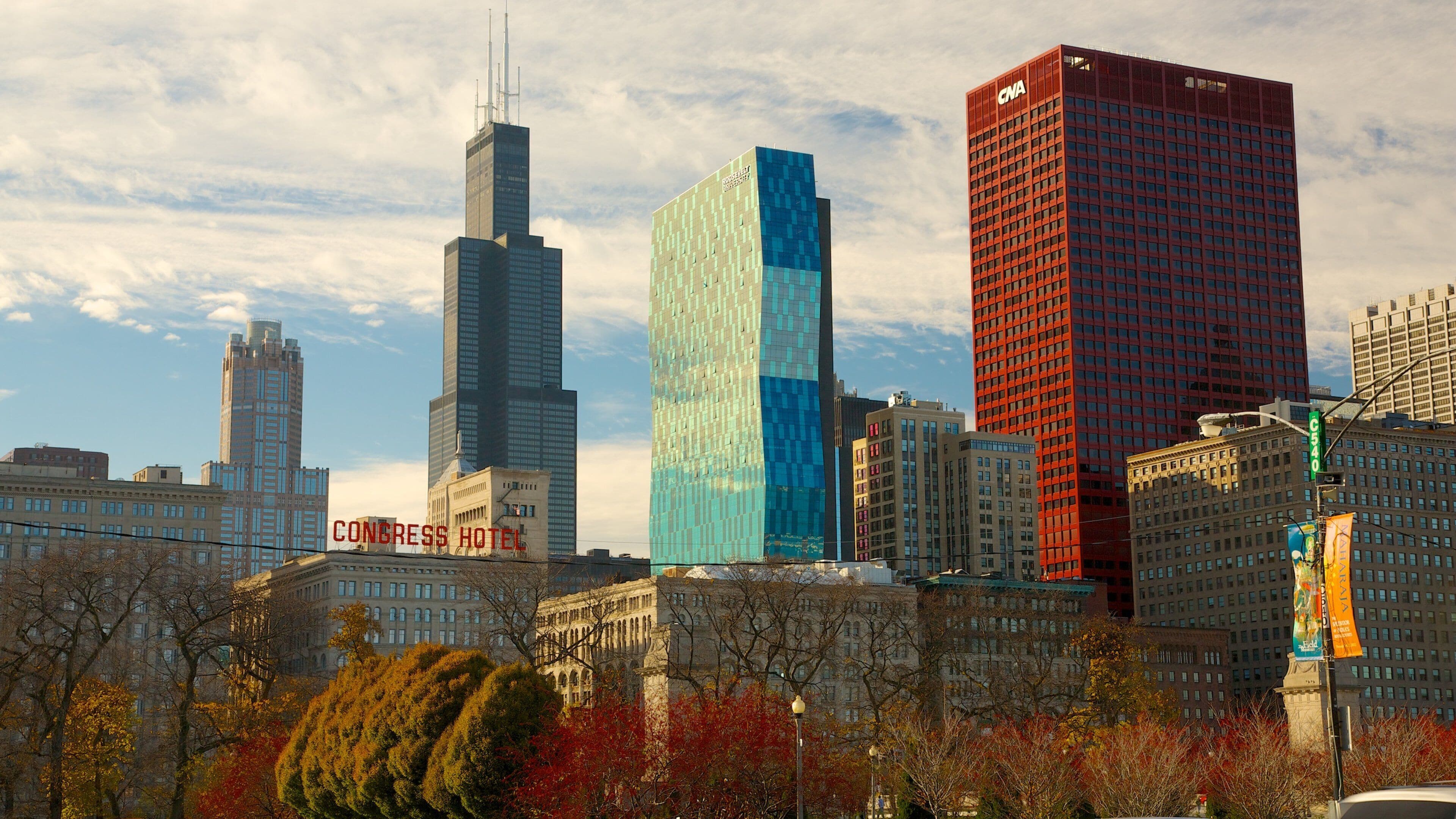 Millennium Park showcases colorful autumn foliage against the Chicago skyline with modern architecture and iconic landmarks