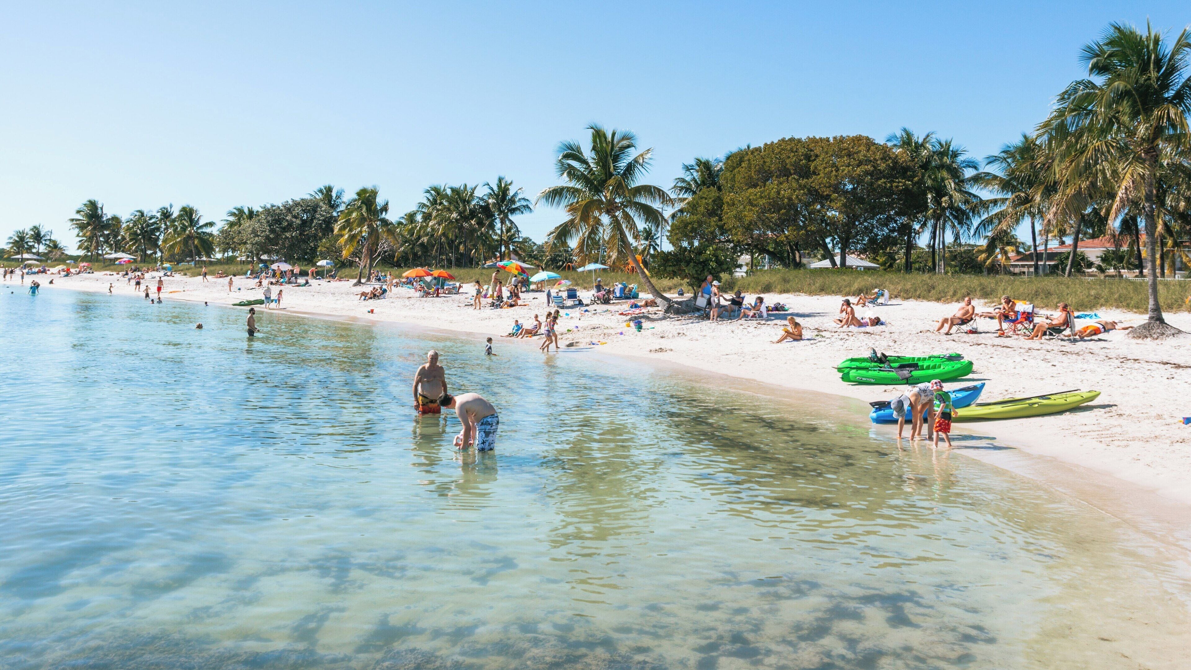 Relaxation and fun at Sombrero Beach in Marathon Florida with clear waters and numerous beachgoers enjoying a sunny day
